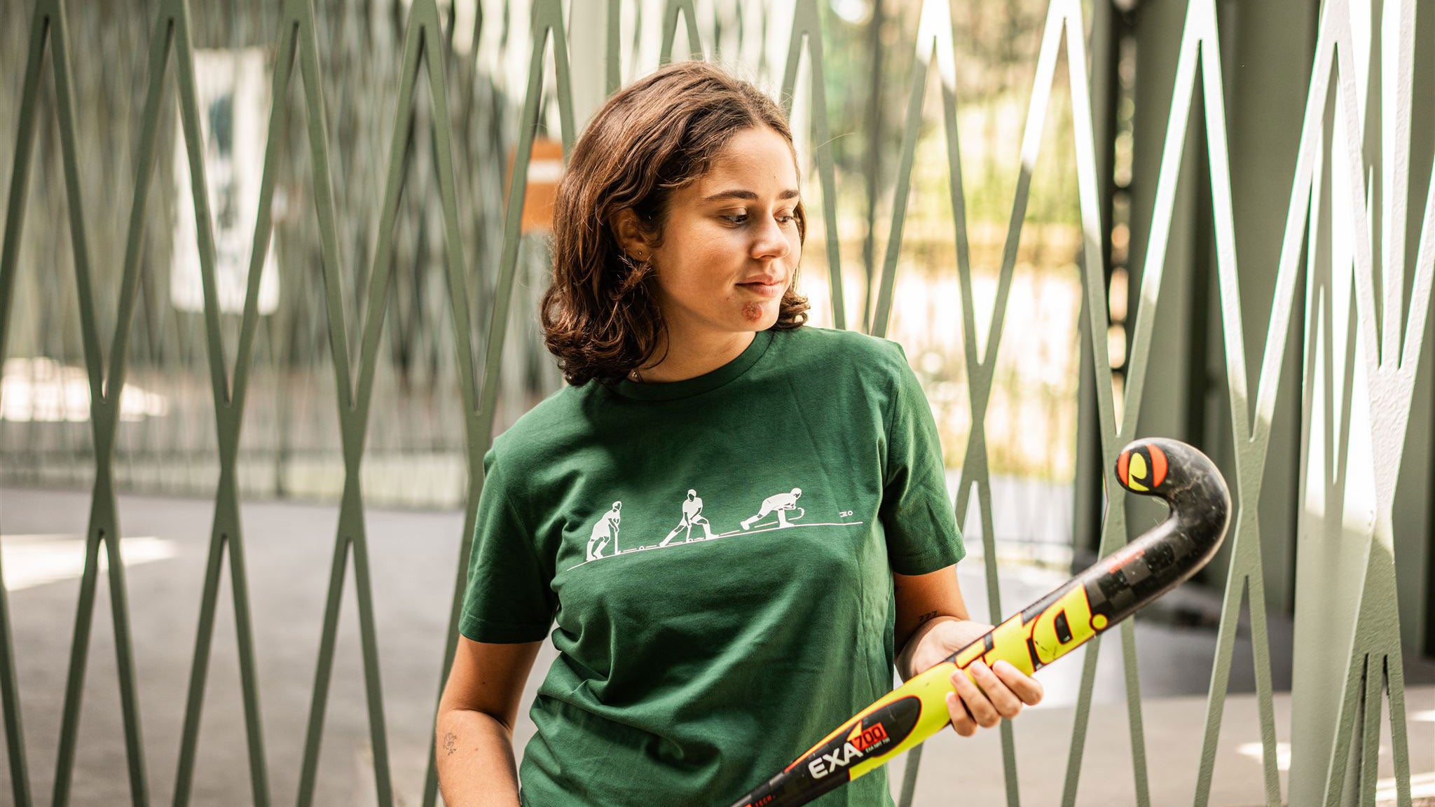 Woman holding a hockey stick and wearing a hockey shirt