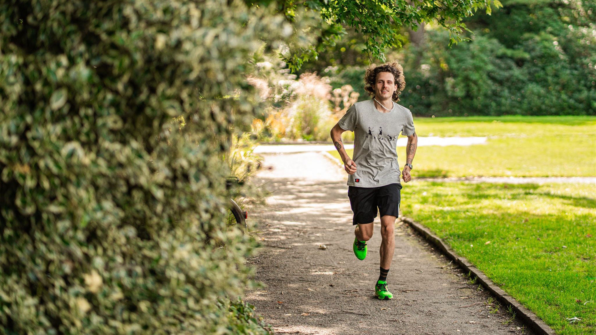 Man running wearing a grey T-shirt with a running drawing.