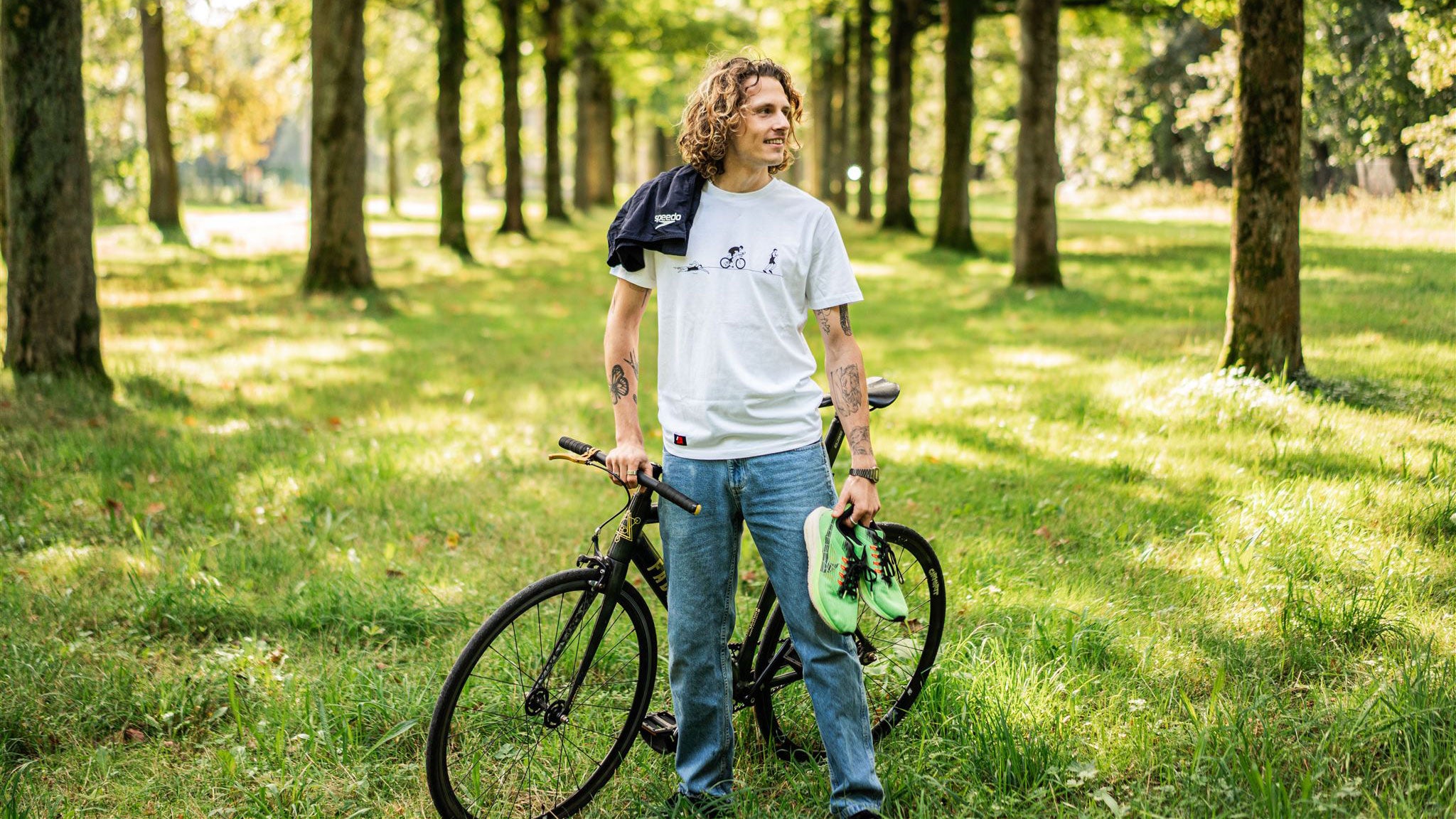 Man with bicycle, running shoes and a swimming shorts.